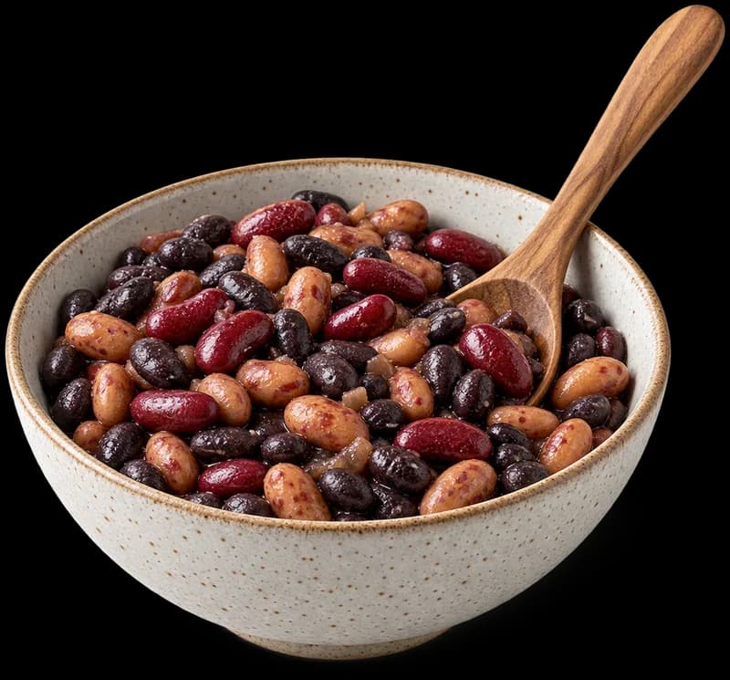 A speckled ceramic bowl of cooked mixed beans (black beans, pinto and kidney beans) with a wooden spoon